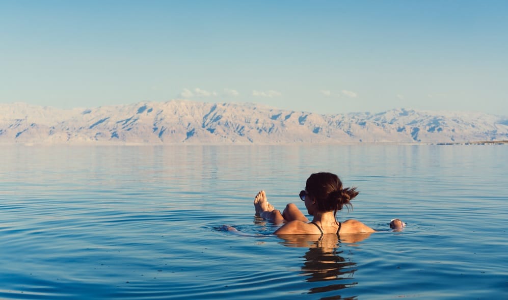 Girl is relaxing and swimming in the water of the Dead Sea in Israel, Best Time to Visit Israel