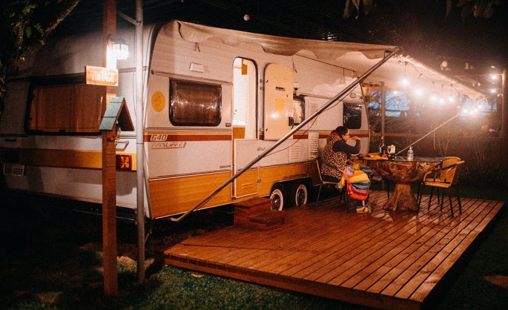 RV illuminated by lights in a campsite